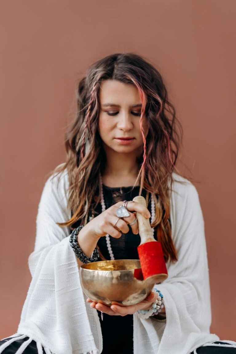 Meditative woman using a Tibetan singing bowl for wellness and relaxation.